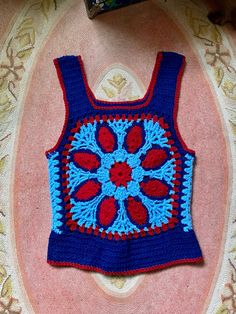 Holy crap this is amazing and special 1970's handmade crocheted tank top Blue, light blue and red colors Great pattern and design Tank sleeves and scoop down pretty low so your bra will definitely hang out That doesn't bother me but it may to some so it's to be noted It's in amazing condition Fits a medium/smaller large there is a little stretch to the yarn Measurements are approximate and taken flat so please double bust and waist for more accurate sizing Bust: 17.5 in Waist: 16 in Length: 24.5 Handmade Blue Tops For Festival, Handmade Blue Cotton Crochet Top, Red Bohemian Patchwork Top, Red Bohemian Top With Patchwork, Blue Cotton Crochet Top For Festival, Cotton Crochet Top With Granny Square For Festival, Bohemian Patchwork Tank Top For Summer, Handmade Sleeveless Tank Top For Beach, Blue Bohemian Top With Crochet Trim