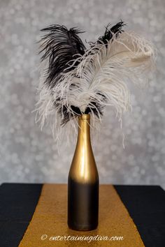 a gold vase with black and white feathers in it