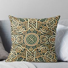 a decorative pillow on a couch with pillows and throw pillows in the shape of celtic symbols