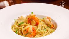 a white plate topped with pasta and shrimp