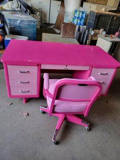 a pink desk with two drawers and a chair