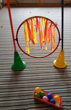 some toys are sitting on the floor in front of a ball pit and an object