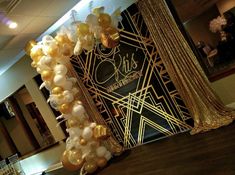 the balloon arch is decorated with gold and white balloons