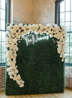 a white flower covered wall with the word love written on it