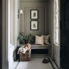 a dog laying on the floor in front of a window with two framed pictures above it