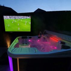 a hot tub in front of a tv with soccer on it