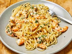 a plate of pasta with shrimp and parsley