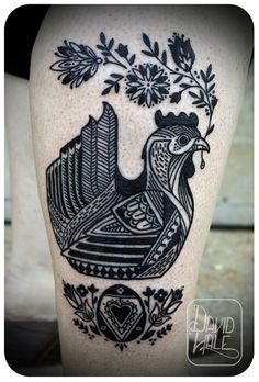 a black and white tattoo on the leg of a woman's legs with an image of a rooster