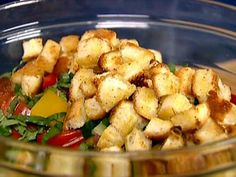 a glass bowl filled with salad and croutons