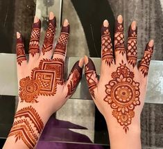 two hands with henna designs on them