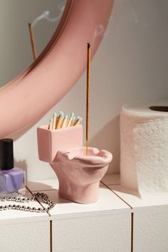 a pink toilet sitting on top of a counter next to a mirror