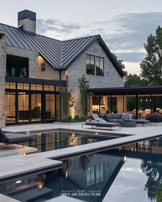 a large house with a pool in front of it and an outdoor lounge area next to it