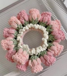 a crocheted wreath with pink and white flowers