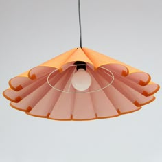 a pink and orange fan hanging from a ceiling light with a white ball in the center