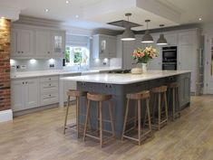 a large kitchen with an island and bar stools in it's center area