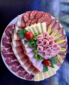 an assortment of meats and cheeses on a plate