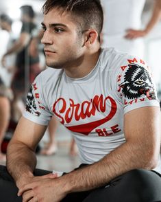 a man sitting down with his hands on his knees and looking off to the side