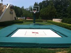 an inflatable basketball court is set up on top of the grass and surrounded by hedges