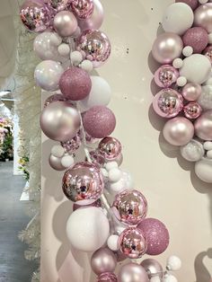 pink and white ornaments are hanging on the wall