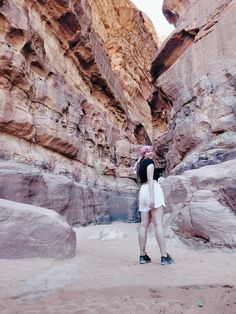 a woman standing in the middle of a canyon