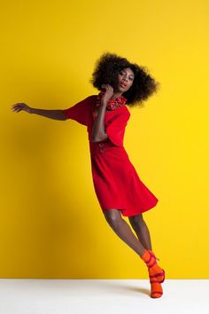 a woman in a red dress is dancing