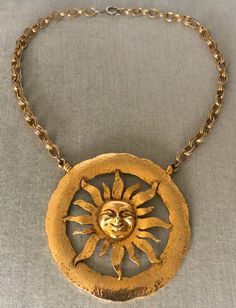 You are looking at a truly spectacular VINTAGE TORTOLANI MID CENTURY MODERNIST MASSIVE ALMOST 4" SUN FACE EXTRA BIG SCULPTURAL DIMENSIONAL ROUND MEDALLION PENDANT BREASTPLATE BIB ON CHAIN CHOKER COLLAR NECKLACE, completely done in Rich Gilt Gold-tone Metal, with an Avant-garde chic look reminiscent of Elsa Schiaparelli, SIGNED, Circa 1970's. VERY REPRESENTATIVE OF THE MID CENTURY MODERNIST CELESTIAL INSPIRED CREATIONS, THIS NECKLACE IS EXQUISITE IN ITS DESIGN AND IT WILL LOOK STUNNING WHEN BEING WORN FEATURING A MASSIVELY HUGE HAMMERED GOLD METAL ROUND MEDALLION CENTERPIECE THAT IS JUST SHY OF 4" IN DIAMETER, THIS SCULPTURAL CELESTIAL INSPIRED SUN CREATION IS JUST GORGEOUS IN ITS DESIGN, SHOWCASING REMARKABLE DIMENSIONAL DETAILS ON THE FACE AND THE RAYS OF THE SUN ITSELF, WHICH IS FRAMED B Schiaparelli Couture Vintage, Sun Medallion, Vintage Schiaparelli, Schiaparelli Couture, Choker Necklace Gold, Choker Collar Necklace, Sun Face, Rays Of The Sun, Sun Necklace