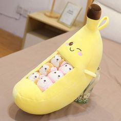 a banana shaped toy sitting on top of a table with dice in it's mouth