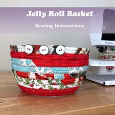 a red and white basket sitting on top of a wooden table next to a sewing machine