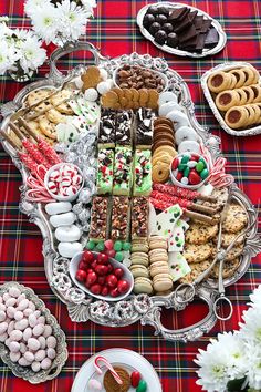 a platter filled with lots of different types of cookies and desserts on top of a table