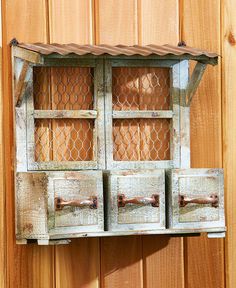 an old window is hanging on the side of a wooden building with metal bars and handles