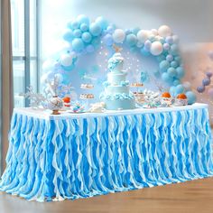 a blue and white dessert table with balloons