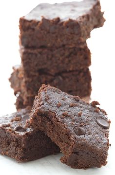 three pieces of chocolate brownie stacked on top of each other with one piece cut out