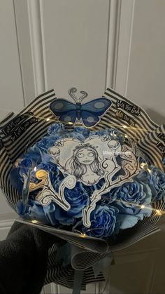 a decorative bowl with blue roses and butterflies on it is sitting in front of a white door