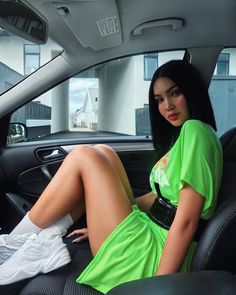 a woman sitting in the back seat of a car with her feet on the dashboard