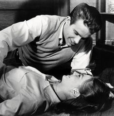 an old black and white photo of two women on the floor with one woman holding her head