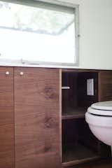 a white toilet sitting next to a wooden cabinet