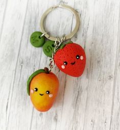 two fruit shaped key chains with faces on them