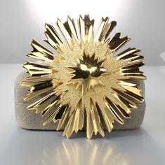 Modernist 1960s gold tone Monet brooch. Design is of a layered starburst employing the use of both polished and textured gold tone surfaces. Brooch measures 2 1/4 inches in width. This elegnat piece It is in excellent vintage condition! Gold Star Brooches As Gift, Art Deco Sun, 1960s Jewelry, Atomic Starburst, Monet Jewelry, Gold Texture, Brooch Pin, 1960s, Gold Tones