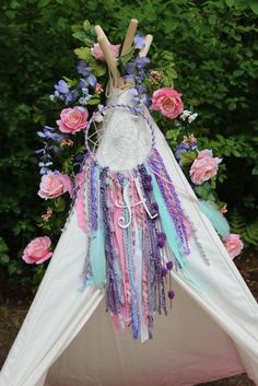 a teepee with flowers and feathers on it