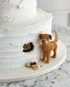 a white cake with a dog figurine next to it