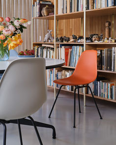 two chairs sitting at a table in front of a book shelf filled with lots of books