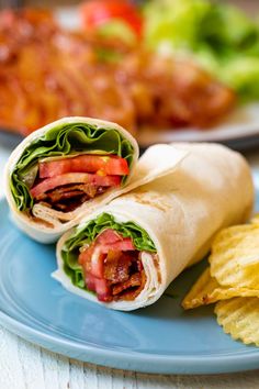 there is a wrap with meat and lettuce on it next to some chips