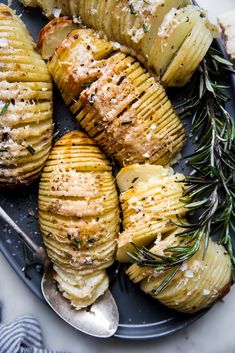 baked potatoes with rosemary sprigs and garlic on a platter, ready to be eaten