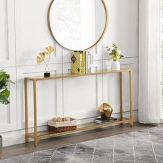 a living room with a round mirror on the wall and a gold console table in front of it