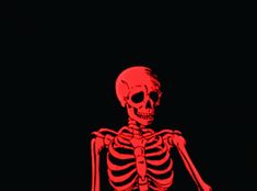 a red skeleton sitting in the dark