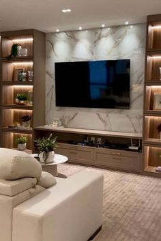 a living room filled with furniture and a flat screen tv mounted to the side of a wall