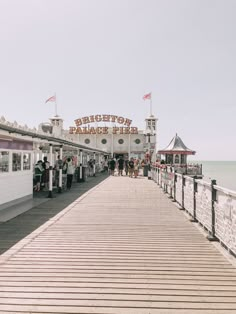 people are standing on the pier near the water