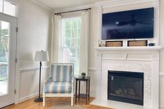 a living room with a fireplace and television on the mantel in front of it