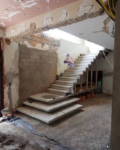 an unfinished room with concrete steps leading up to the second floor