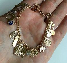 "18k gold filled charm (virgin mary,elephant,evil eye,hamsa,money bag,heart,crystal ,horseshoe cross)bracelet for good luck and protection..7.25\" long . pulsera de buena suerte en18k gold filled. para proteccion y buena suerte.7.25\" largo." Gold Jewelry Accessories, Money Bracelet, Horseshoe Cross, Xoxo Jewelry, Dope Jewelry Accessories, Evil Eye Hamsa, Pretty Jewelry Necklaces, Teeth Jewelry, Wrist Jewelry